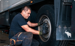 Mechanic changing tire in a trailer