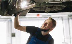 Mechanic with a lamp preparing to replace brake calipers