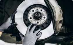 Hands of mechanic doing replacement of brake discs and drums